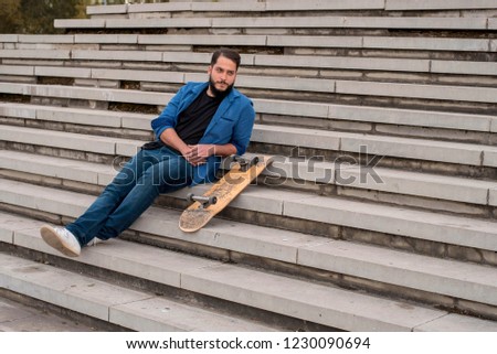 Young skateboarder relax on the concrete steps 