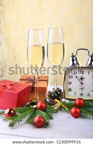 New Year or Christmas decorations with glasses wine, gift boxes, candles and balls. greeting card. Selective focus, copy space.