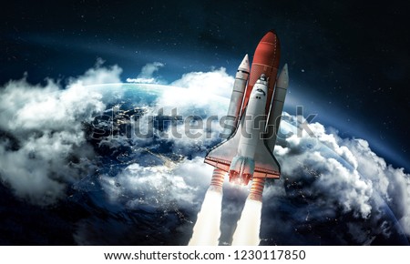 Space shuttle in the space near Earth. Clouds and sky on background. Atmosphere. Elements of this image furnished by NASA Royalty-Free Stock Photo #1230117850