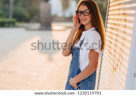young positive attractive pretty girl in stylish glasses at morning warm sunshine