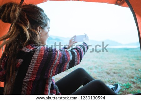 close up a woman take a picture with smartphone after wake up in the morning, in a tent