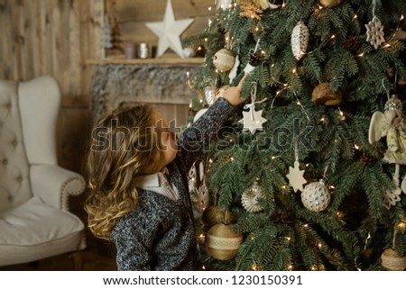 Beautiful little girl decorating Christmas tree