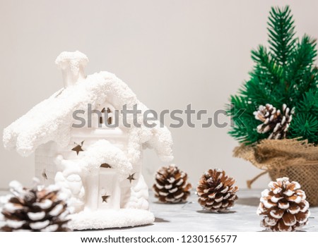 Art Christmas holidays composition on a light background background with Christmas tree decorations. New Year's house. Beautiful cones. New Year card.