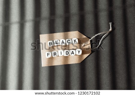 Sale banner with text word Black Friday on cardboard label on dark background. Black Friday sale concept