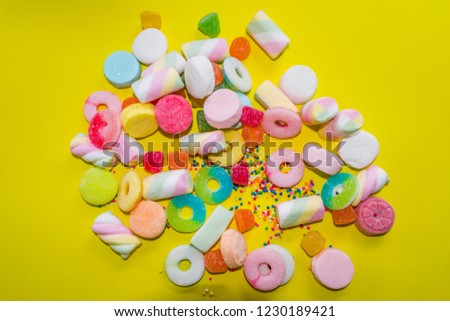 gummies and candies on yellow background