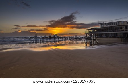 Dawn reflections high tide coastal gold coast beach Currumbin sandy rocky shore cloudy clear sky