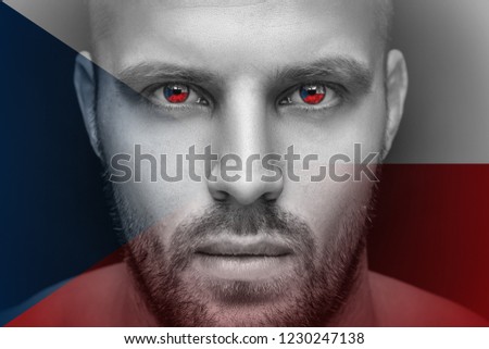 Portrait of a young serious man, in whose eyes the reflected national flag of the Czech Republic, against an isolated black background and flag
