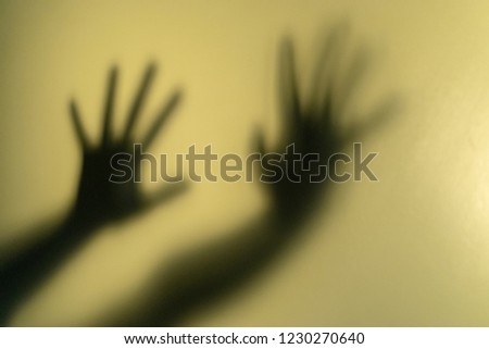 Blurry shadow of the hand with sign of HELP on wall background. Safety and hopeless concept