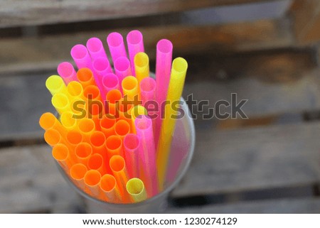 Top view of end of multicolored plastic drinking straws in the glass, as sign for heterogeneity or teamwork. Environment about reject or reduce plastic drinking straws.