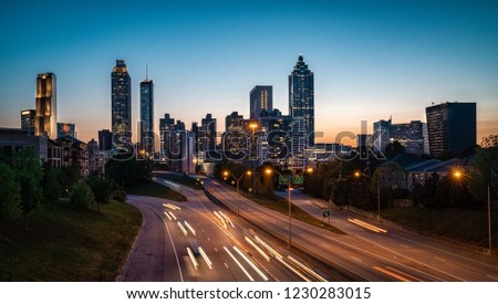 Evening car traffic flowing against city skyline. Late sunset light in the background. Atlanta, USA.