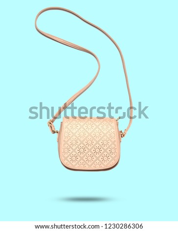 3D photo with the shadow of a fashionable leather bag isolated on blue pastel background. Minimalism, levitation. Royalty-Free Stock Photo #1230286306