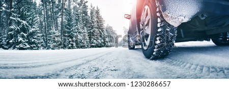 Closeup of car tires in winter on the road covered with snow Royalty-Free Stock Photo #1230286657