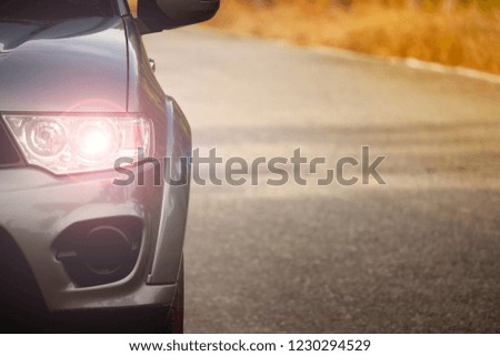 Front view of gray car with nature tree.Trip travel at country. Stop on asphalt road.Effect open light.