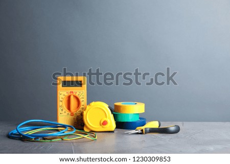 Set of electrician's tools on table against gray background. Space for text