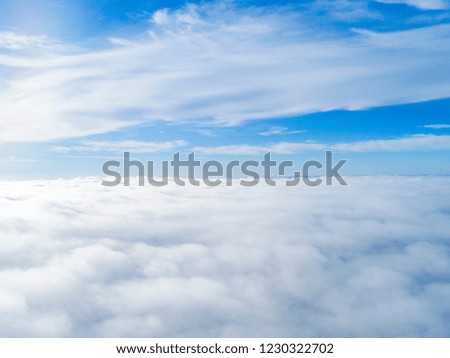 Aerial view White clouds in blue sky. Top. View from drone. Aerial bird's eye look. Aerial top view cloudscape. Texture of clouds. View from above. Sunrise over clouds