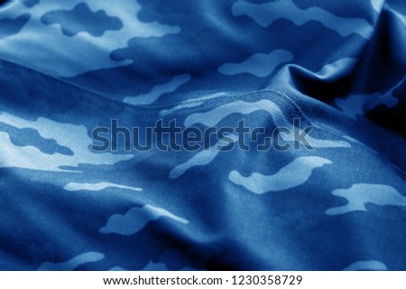 Old camouflage cloth with blur effect in navy blue tone. Abstract background and texture for design abd ideas.