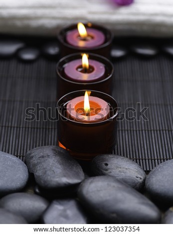 row of candle with towel and zen rock at spa