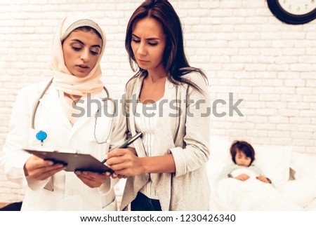 Arabic Doctor's Appointment Mother with Sick Son. Confident Muslim Female Doctor. Child at the Pediatrician. Hospital Concept. Healthy Concept. Pediatrician Writes a Prescription. Child Patient Doctor