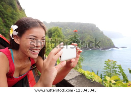 Tourist on Hawaii taking photo with camera phone during car road trip on the famous Road to