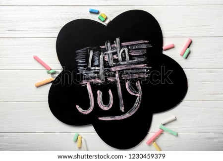 Blackboard with color chalks on white wooden background. 4th July celebration