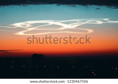 Aerobatics over city at dawn. Aviator performed complex stunt. Drunk pilot of plane in sky. Unusual airshow at sunrise. Drunk driving. Entangled plume from airplane. Amazing flying.