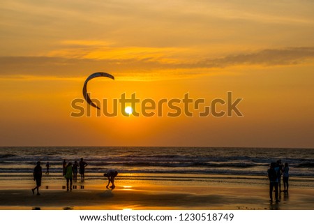 North Goa / India - Dec 2017: Colorful sunset on the shores of the Arabian Sea. Paragliding on Arambol beach.