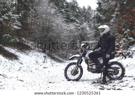 Rider man on a motorcycle Winter motocross. snowy forest. the snow under the wheels of a motorcycle Enduro. off road dual sport travel tour, active life style concept