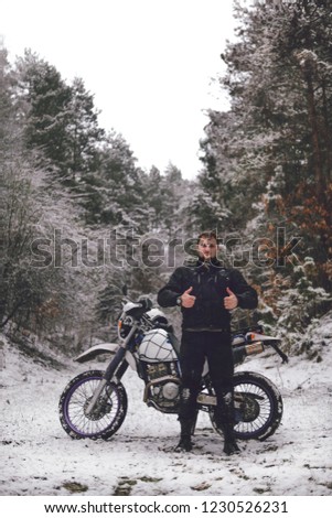 Rider like man on a motorcycle Winter motocross. Skid on a snowy forest. the snow from under the wheels of a motorcycle Enduro. off road dual sport travel tour, active life style concept vertical