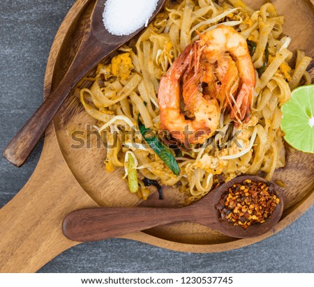 Thailand or asia food Fried rice Noodles and shrimp "Pad Thai"with and vegetables in black dish on background.