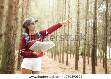 Hipster tourist hold and look map on trip, lifestyle concept adventure, traveler with backpack on background forest landscape horizon, young girl hiker pointing hands on trekking plan.