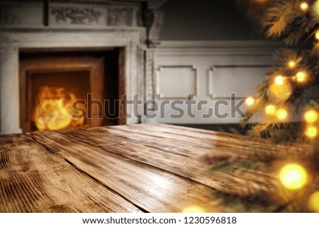 Table background of free space for your decoration and fireplace background with christmas tree 