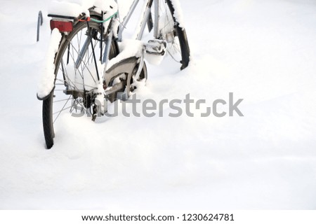 Bicycle covered with snow. Selective focus and shallow depth of field.
