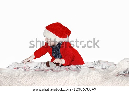 Closeup portrait of a cute little baby boy wearing red Santa Claus hat isolated on white background, traditional Christmas costume