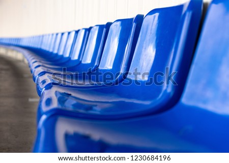 Stadium seats, blue color. Soccer, football or baseball stadium tribune without fans. End of the game.