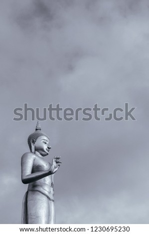 Standing golden Buddha statue or Phra Buddha Mongkol Maharaj under clear sky of Hat Yai municipal park, Songkhla - Thailand