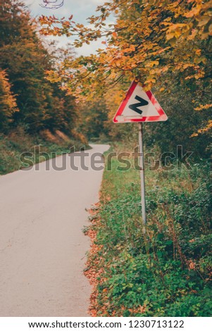Roadway and yellow and green winding road sign in Serbia