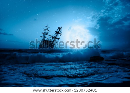 Sailing old ship in storm sea - Night sky with moon in the clouds "Elements of this image furnished by NASA Royalty-Free Stock Photo #1230752401