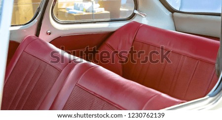 Red leather seats of an old fashioned compact car