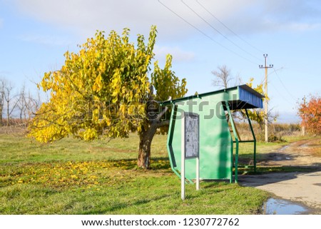 Bus stop in the village. The stopper next to the tree