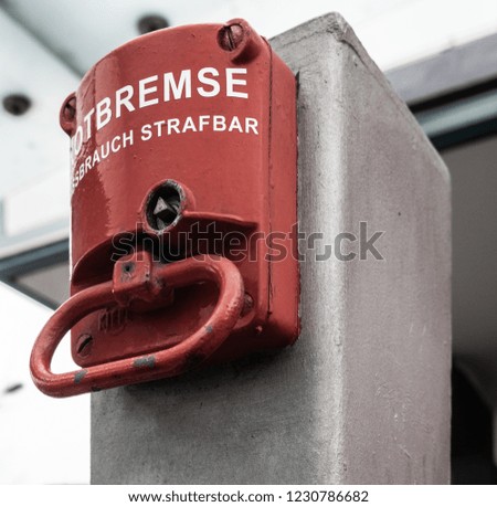 Red emergency brake to stop a large rolling staircase, with German inscription "emergency brake, misuse punishable"