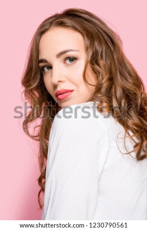 Serious business woman standing, looking at camera isolated on trendy pink studio background. Beautiful, young face. Female half-length portrait. Human emotions, facial expression concept