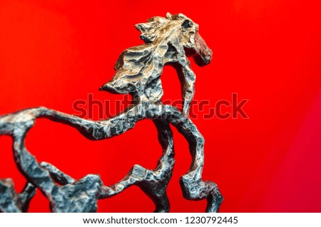 Sculpture or statue of body structure horse move forward  to the goal with red background.