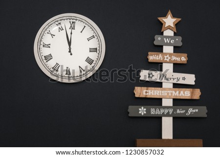 wooden christmas tree and new year clock on dark background