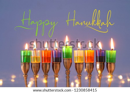 image of jewish holiday Hanukkah background with menorah (traditional candelabra) and colorful oil candles