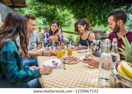 Happy cheerful  group of friends having breakfast in a farmhouse - Young people eating in the garden, concepts about healthy lifestyle and food