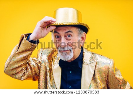 Funny and extravagant senior man posing on colored background - Youthful old man in the sixties having fun and partying Royalty-Free Stock Photo #1230870583