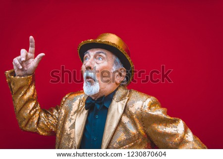 Funny and extravagant senior man posing on colored background - Youthful old man in the sixties having fun and partying Royalty-Free Stock Photo #1230870604