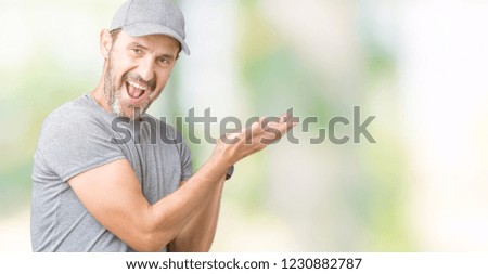 Handsome middle age hoary senior man wearing sport cap over isolated background Pointing to the side with hand and open palm, presenting ad smiling happy and confident