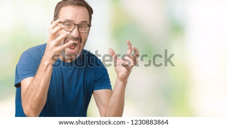 Handsome middle age hoary senior man wearin glasses over isolated background Shouting frustrated with rage, hands trying to strangle, yelling mad