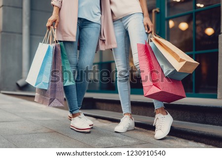 Look what we got. Cropped portrait of young lady and her mother holding colorful shopping bags Royalty-Free Stock Photo #1230910540